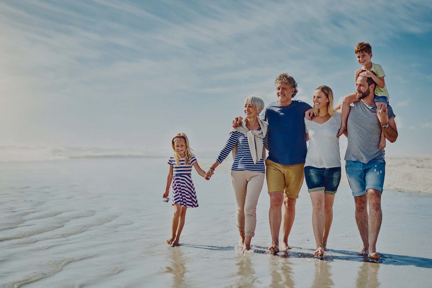 Family enjoying a walk together on the beach.